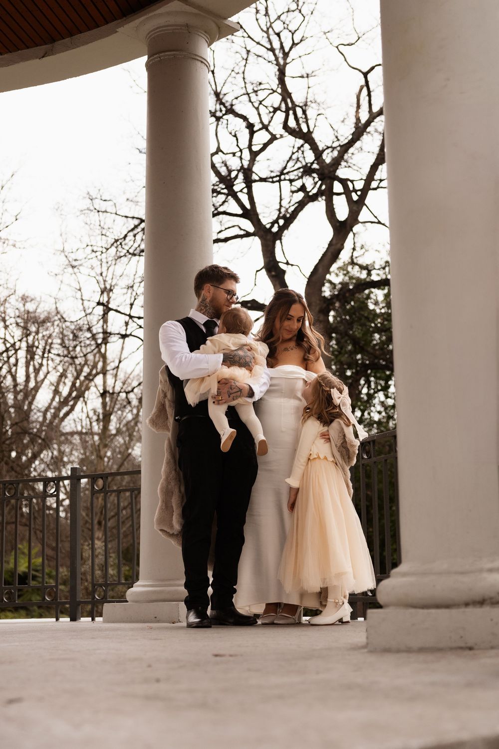Newlyweds hugging and looking at their kids during elopement session at Hagley Park, Christchurch