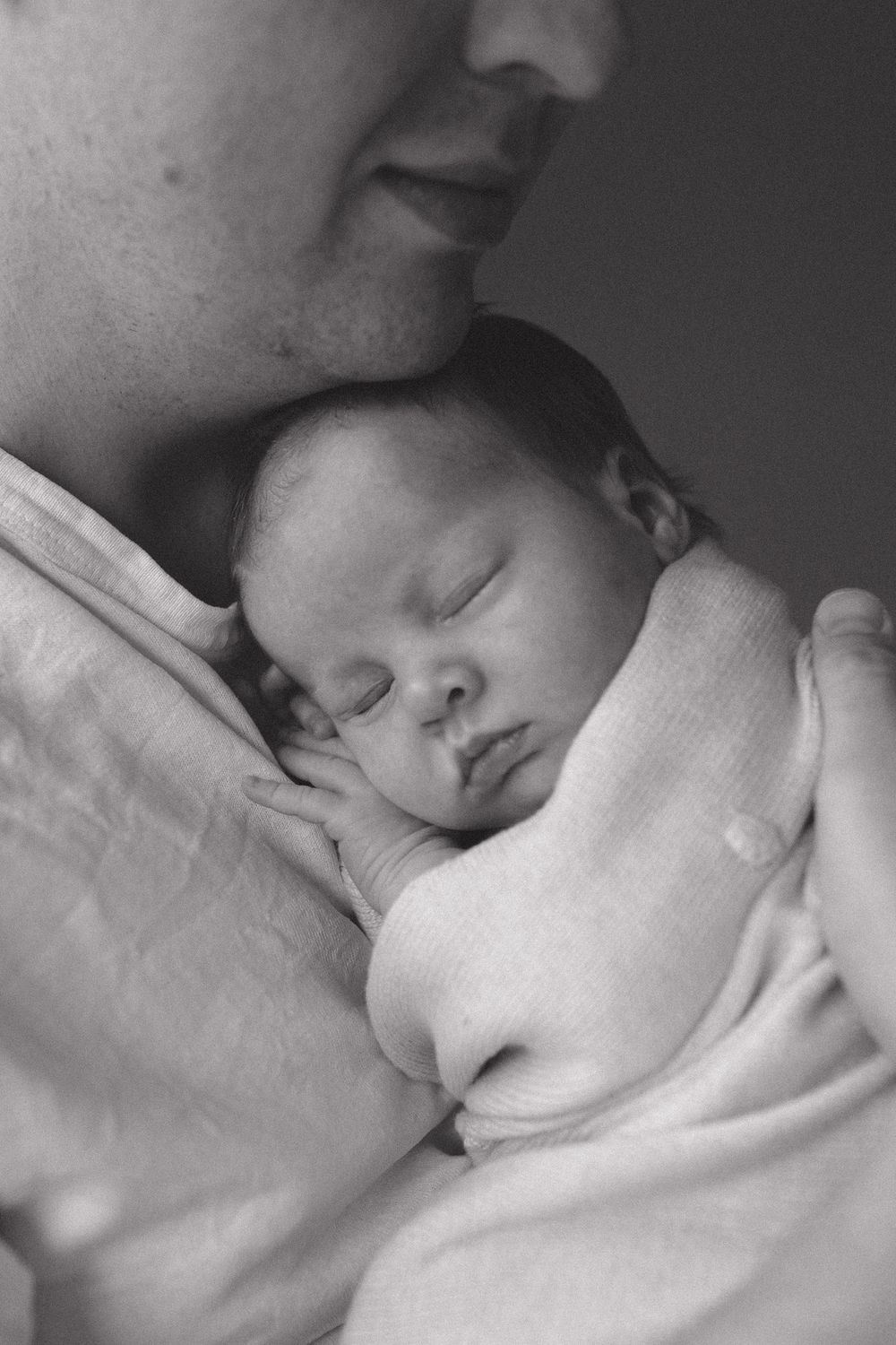 Peaceful sleeping baby wrapped in white blanket shown in black and white close-up photo sequence.