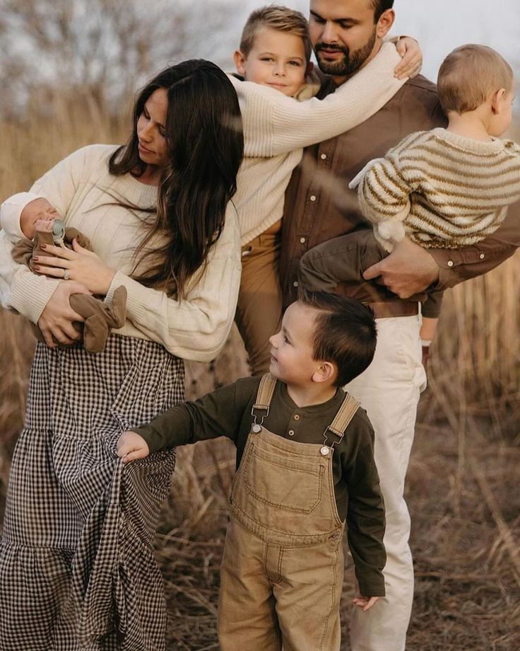 Family sharing warm embraces and candid moments together outdoors during a golden autumn photoshoot.