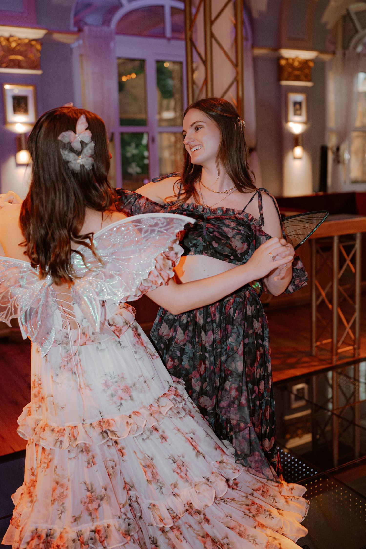 Two people dancing together in an elegant venue with warm lighting and decorative details.