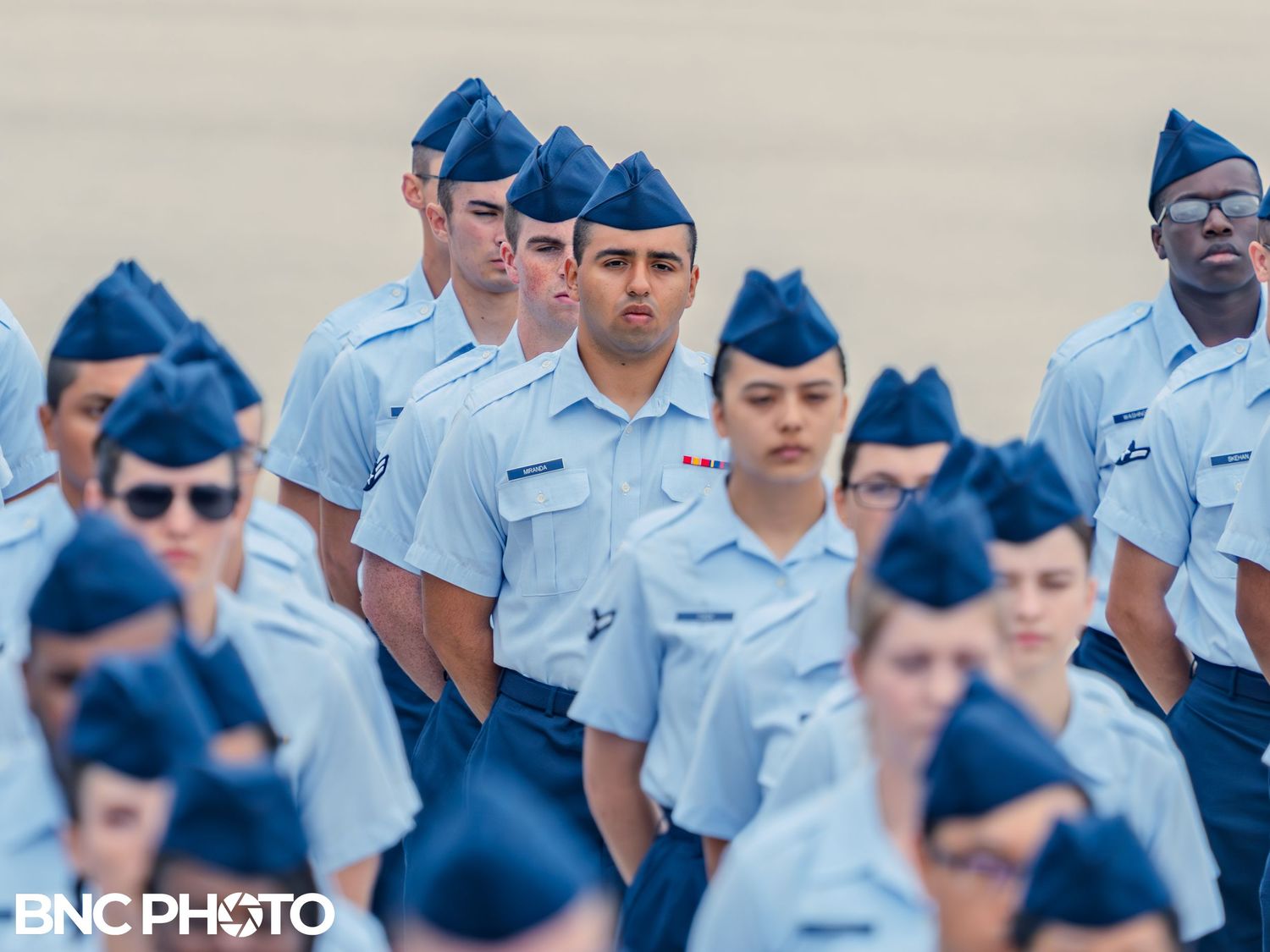 Group of U.S. Air Force trainees in light blue uniforms standing in formation during basic military training at Lackland AFB.