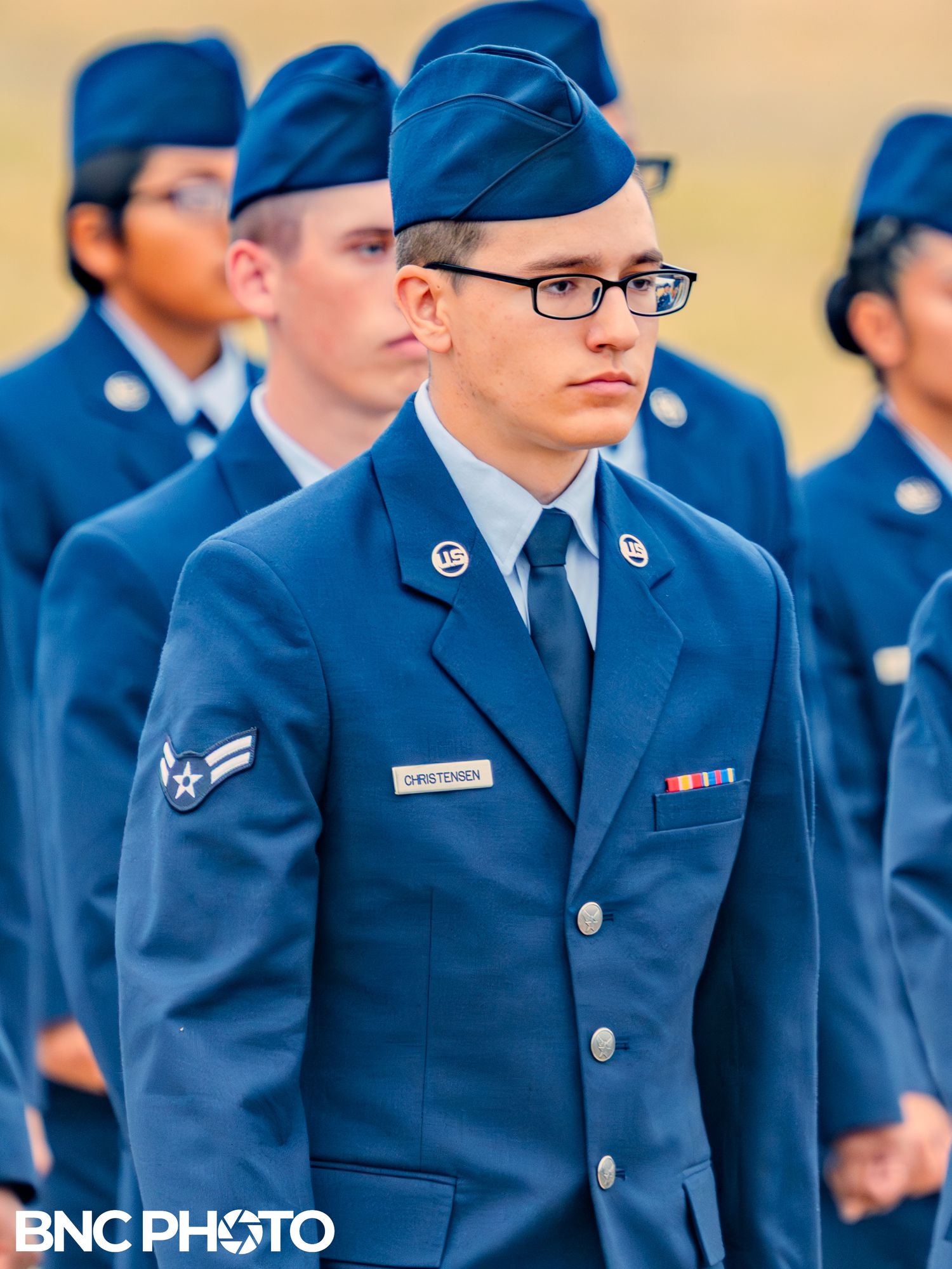 U.S. Air Force Airman in blue dress uniform standing in formation during a graduation ceremony at Lackland AFB.