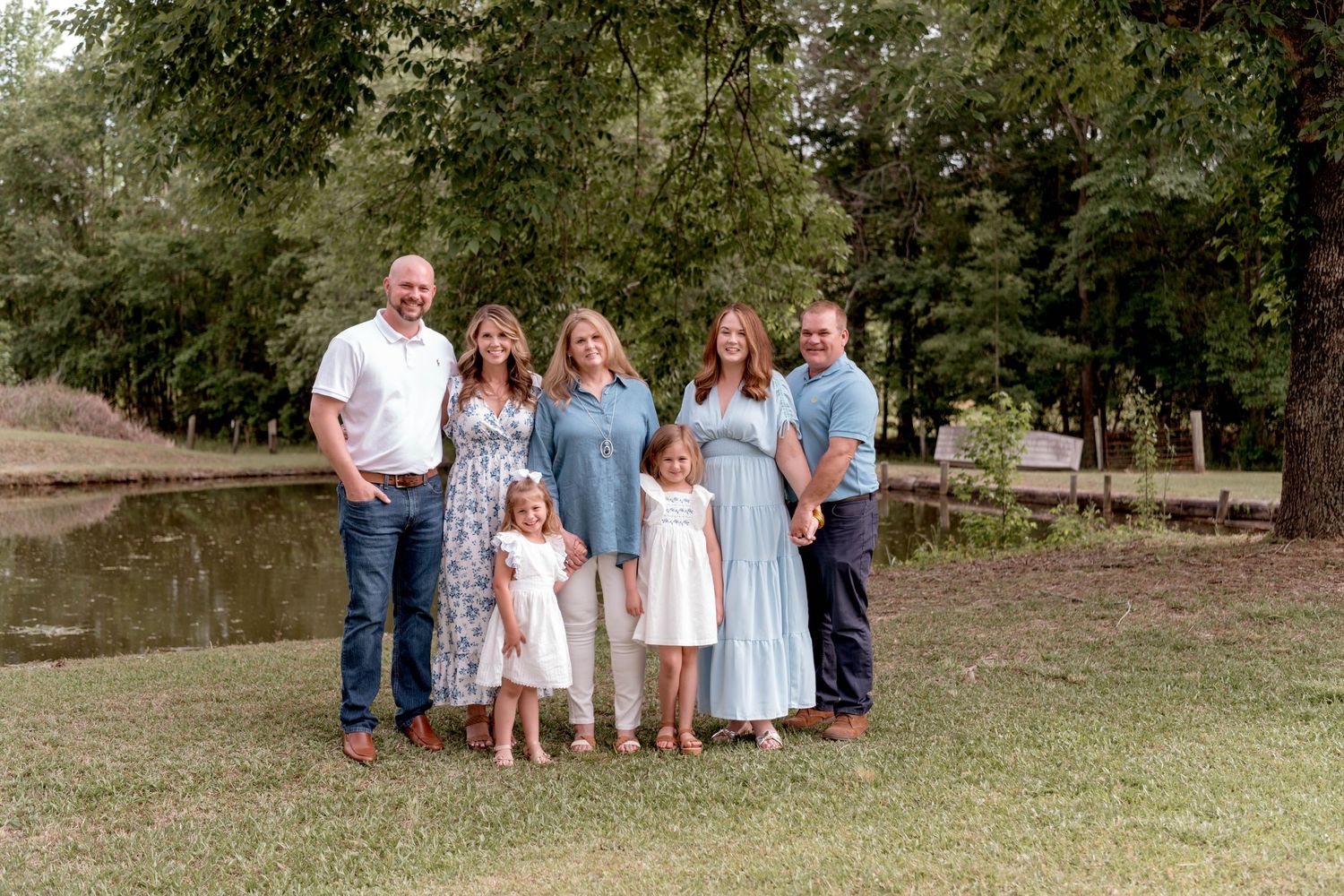 Outdoor family portrait session in casual attire against natural landscape.