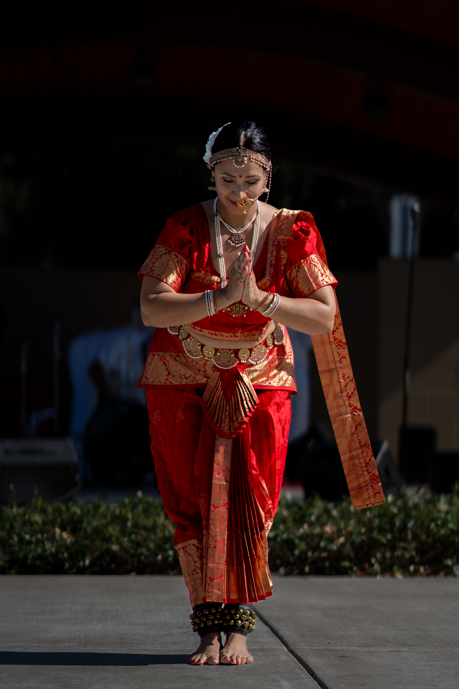 Classical Indian dance performance featuring intricate hand gestures and red traditional attire.