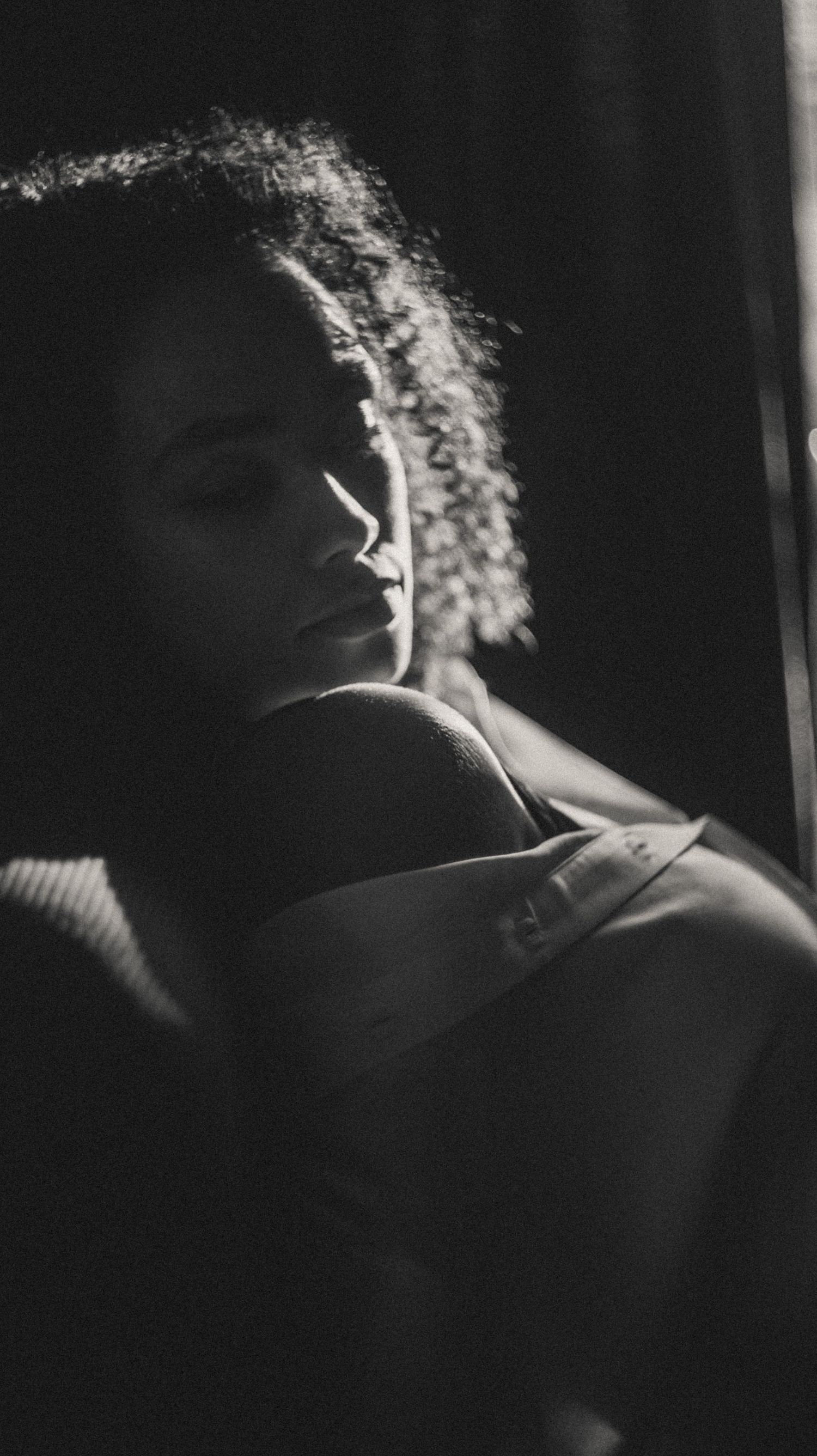 Silhouette-style analog photo of a woman in a cozy introspective boudoir session.