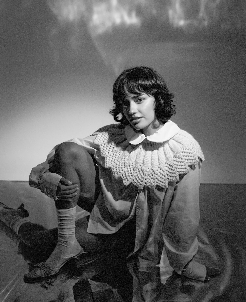 Black and white portrait in vintage-style ruffled collar sweater.