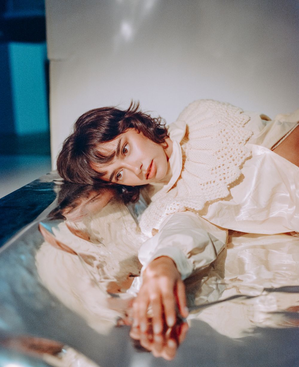 Dreamy fashion portrait featuring cream colored ruffled costume in soft lighting.