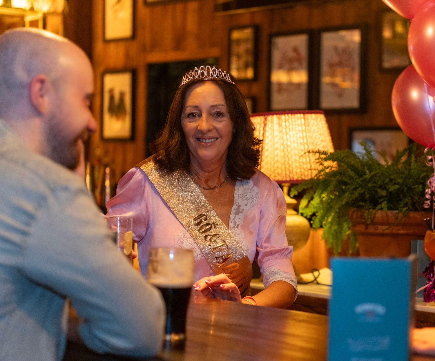 Woman smiling enjoying her birthday party while wearing a tiara