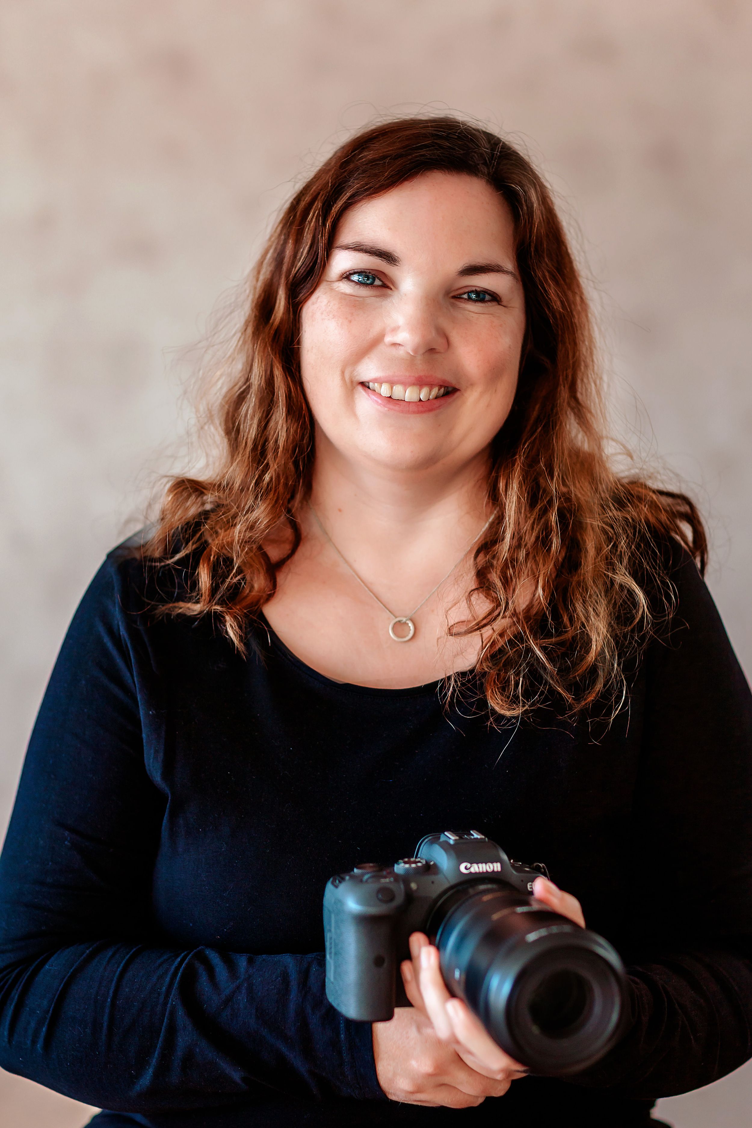 Selvportrett av fotograf Tone Ørstavik som smiler til kamera.