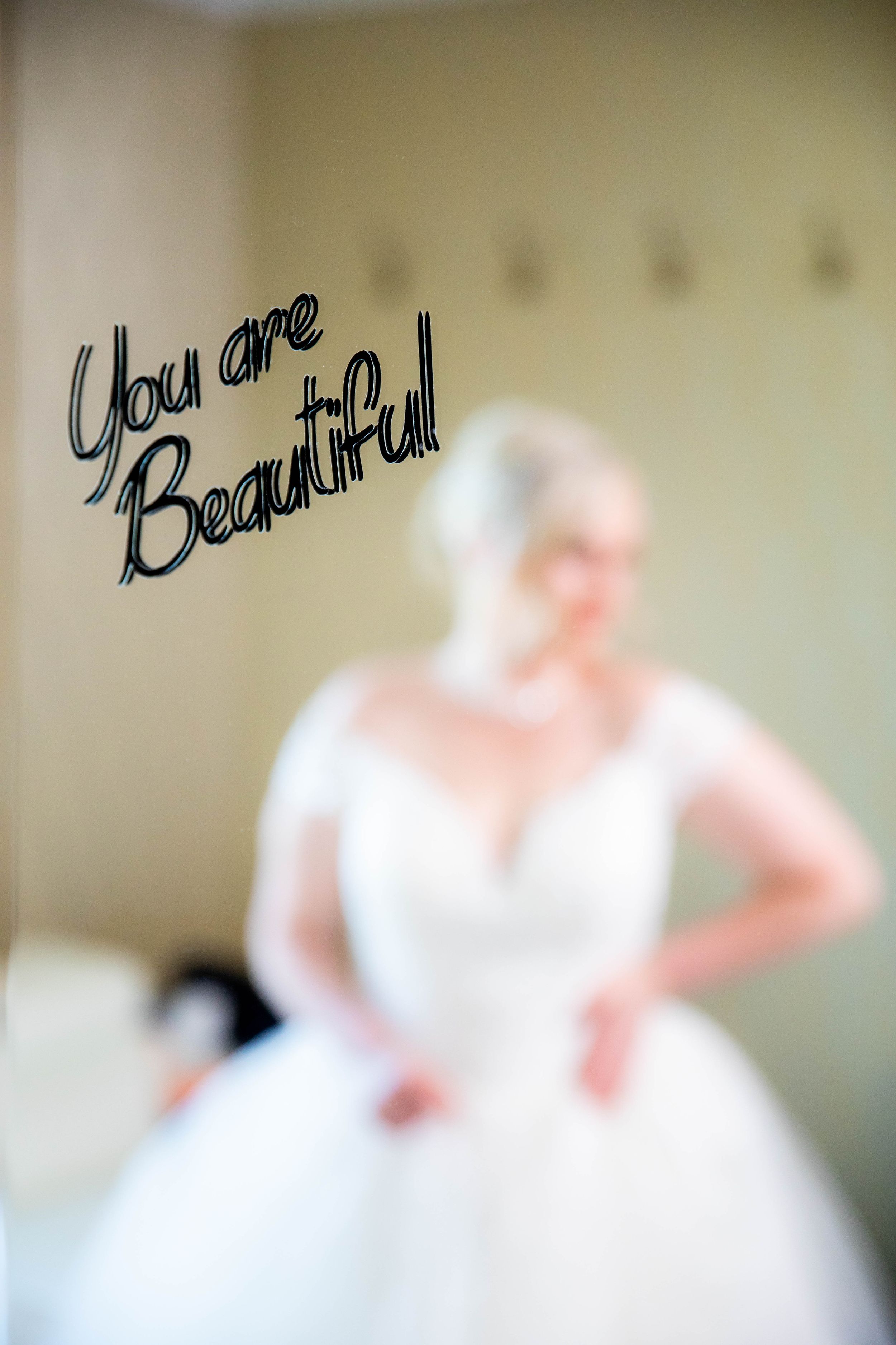 Wedding dress silhouette with decorative 'You are Beautiful' text in foreground.
