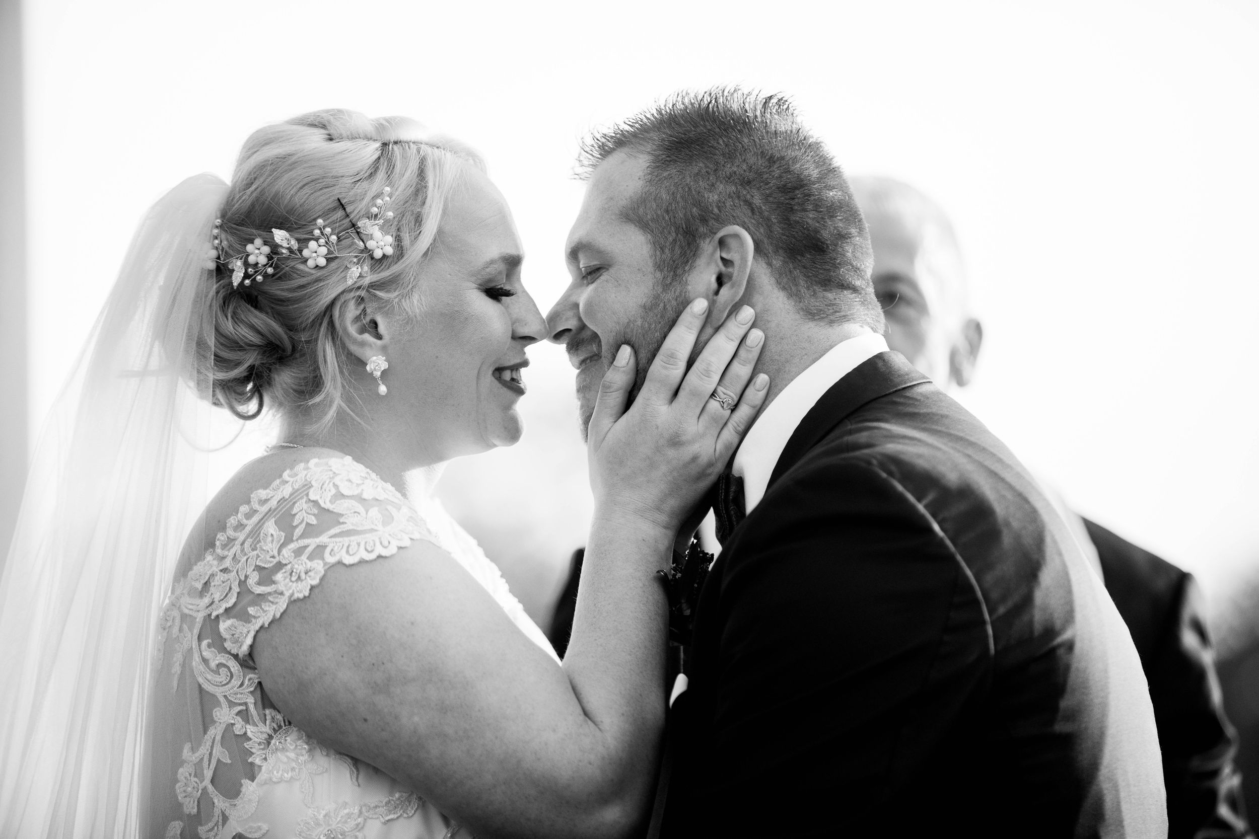 A tender moment captured in black and white as newlyweds share their first kiss.