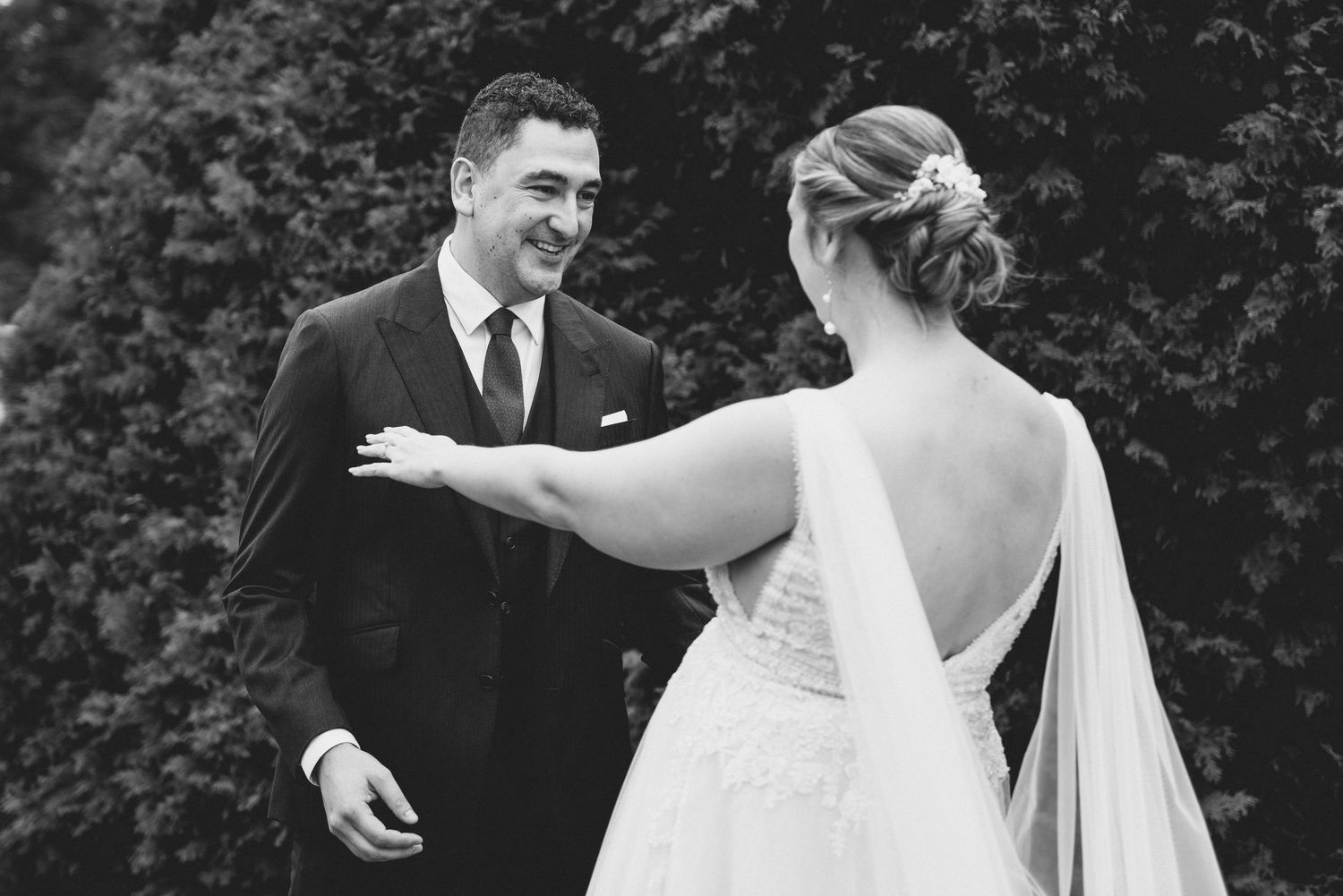 A candid black and white first look moment between newlyweds during their wedding celebration.