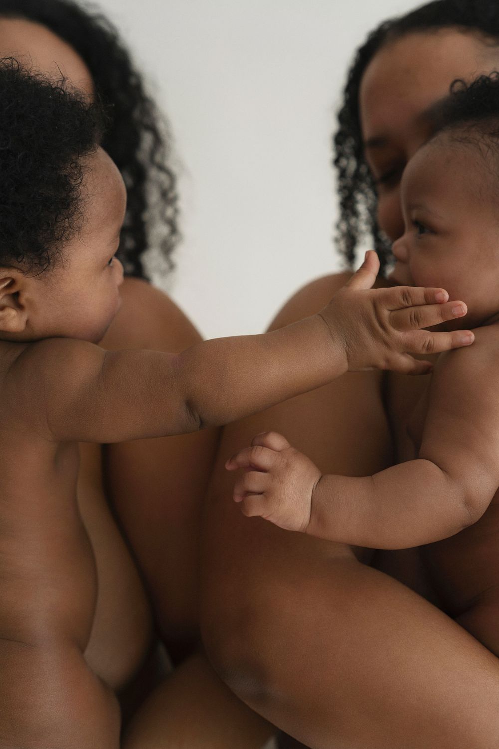 Artistic portrait capturing tender interaction between baby's hand and face.