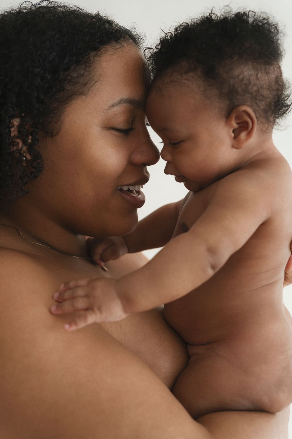 Intimate skin-to-skin portrait showing loving connection in natural lighting.