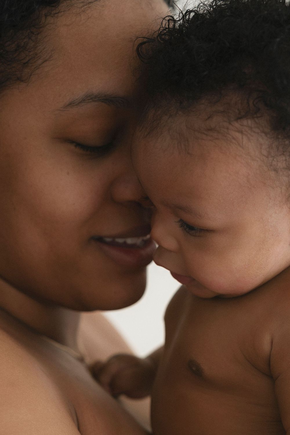 Intimate close-up portrait showing tender nose-to-nose moment with baby.