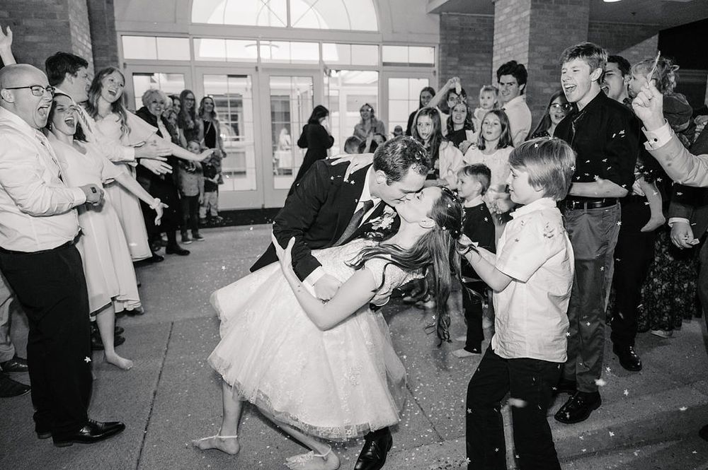 A black and white vintage photograph of people dancing at what appears to be a wedding reception or celebration.
