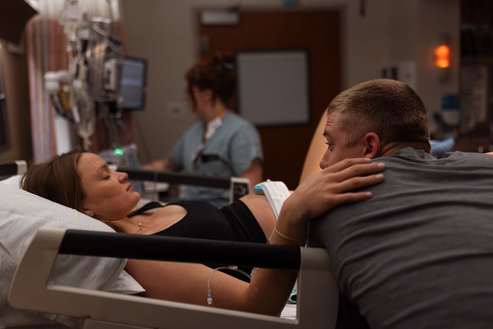 Hospital scene showing medical care being provided to patient on exam bed.