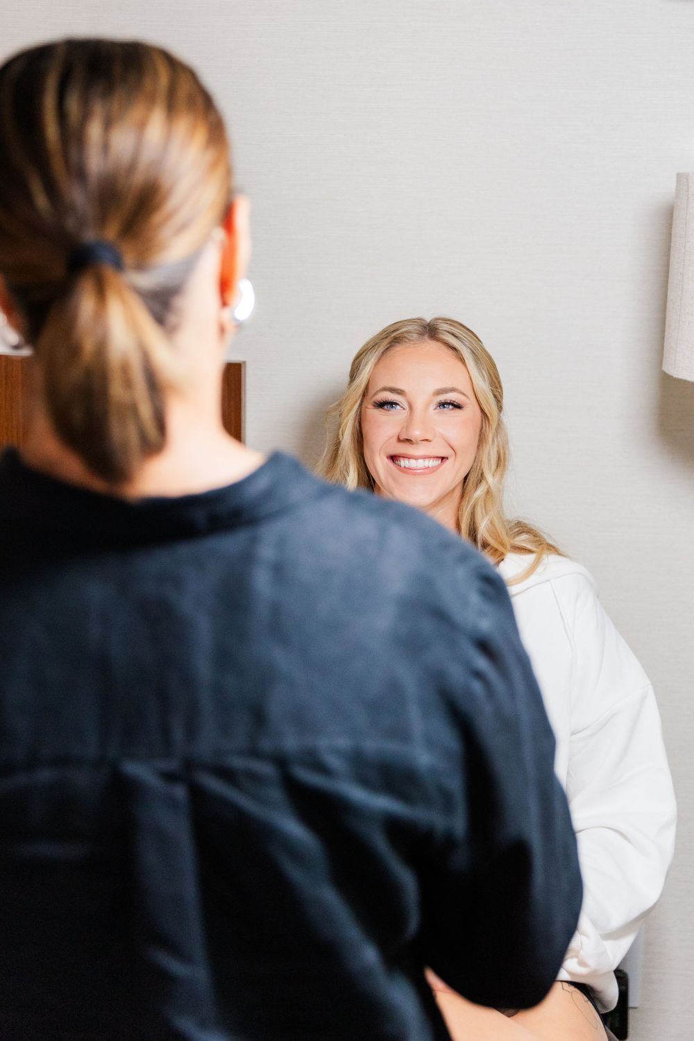 Wedding preparation scene with someone getting ready in front of a mirror.