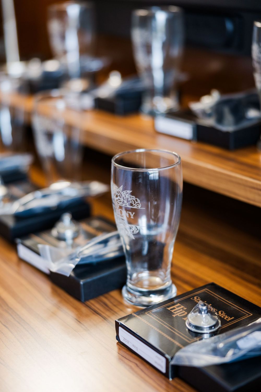 Wedding favors and empty beer glasses arranged on wooden table.