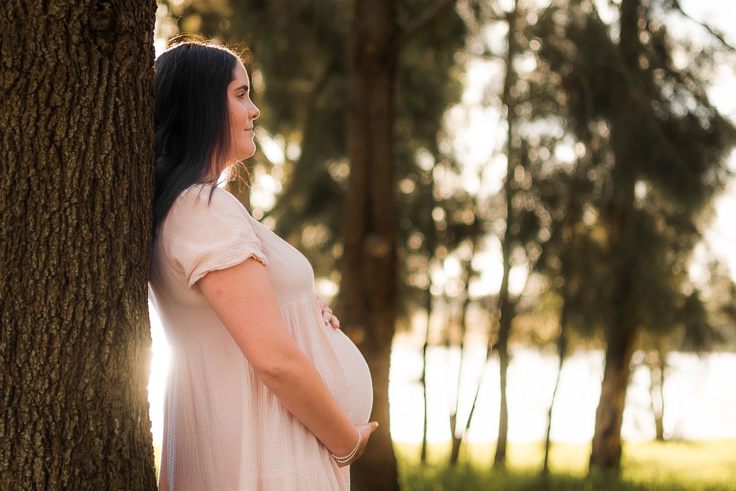 Maternity photoshoot at Kingaroy Dam during golden hour, capturing a glowing expectant mother in warm sunlight