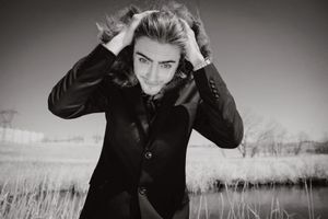 Dramatic black and white portrait series in a field with moody lighting and natural scenery.
