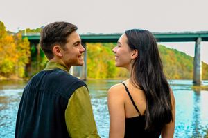 A couple shares intimate moments by a lake in a series of romantic outdoor photos during golden hour.