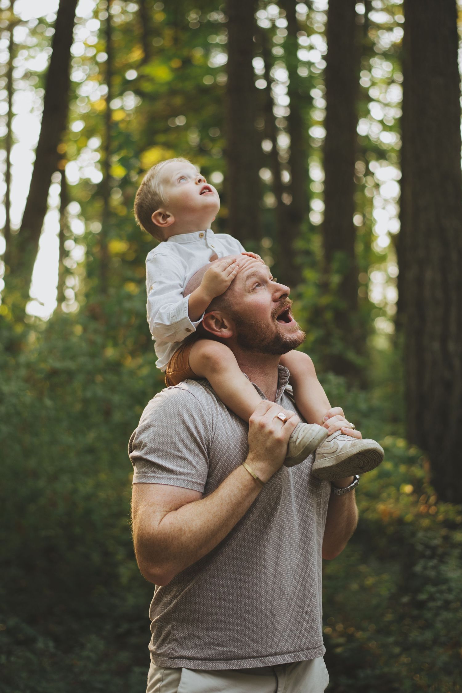 A joyful moment shared between two people in a forest setting.