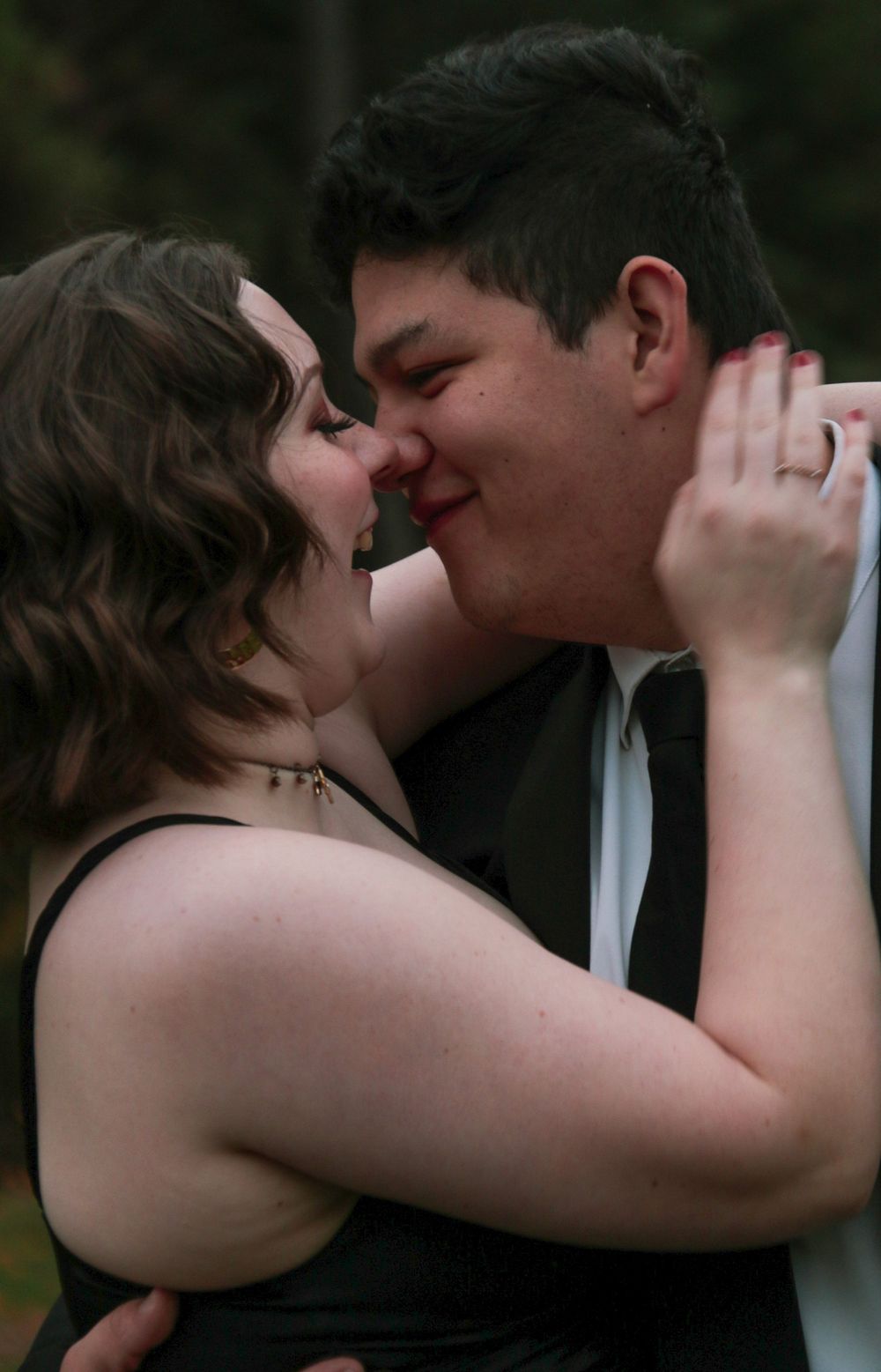 Close-up of couple about to kiss, woman with red nails gently holding mans face.