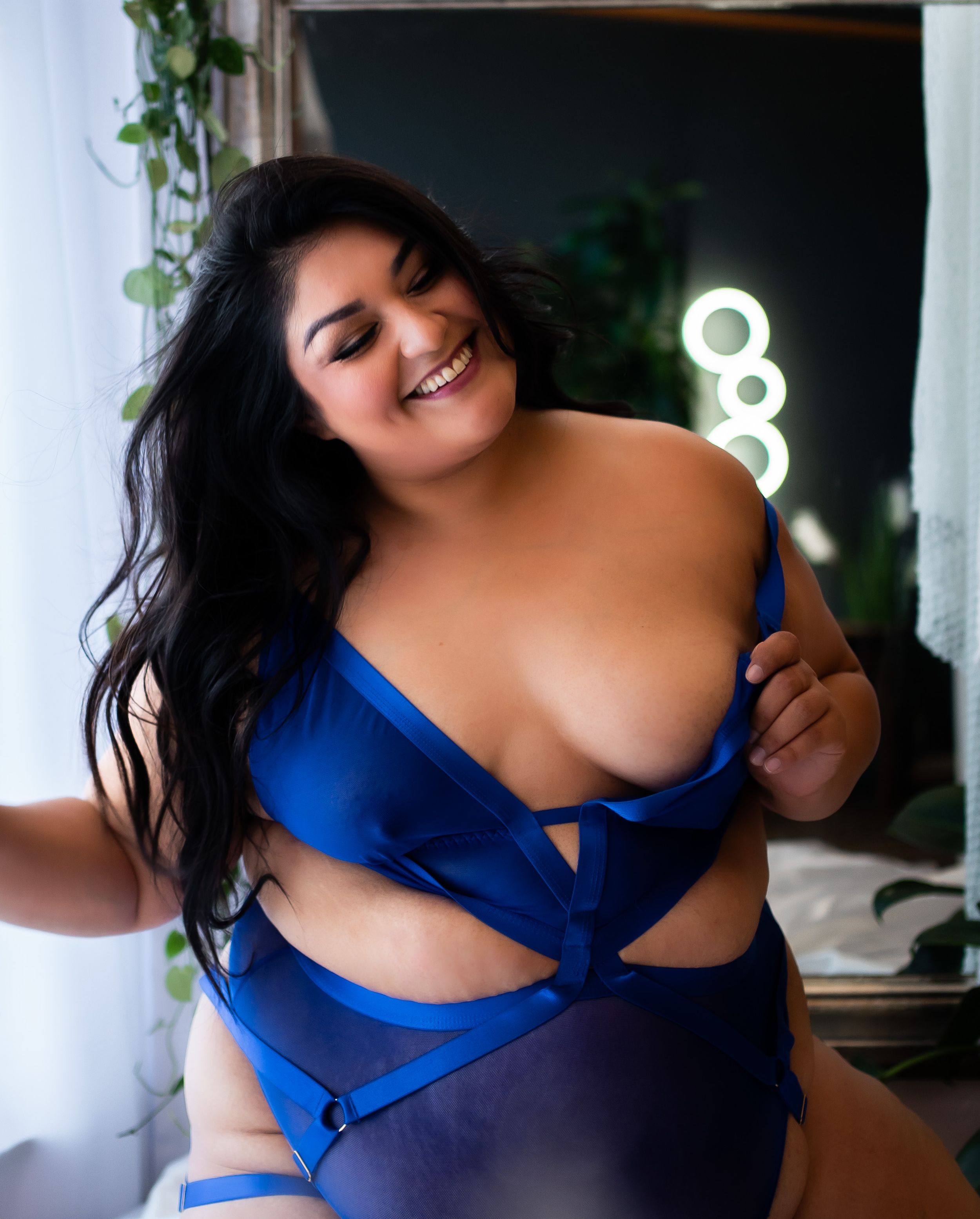 A woman in a royal blue top poses seductively across multiple artistic boudoir photos.
