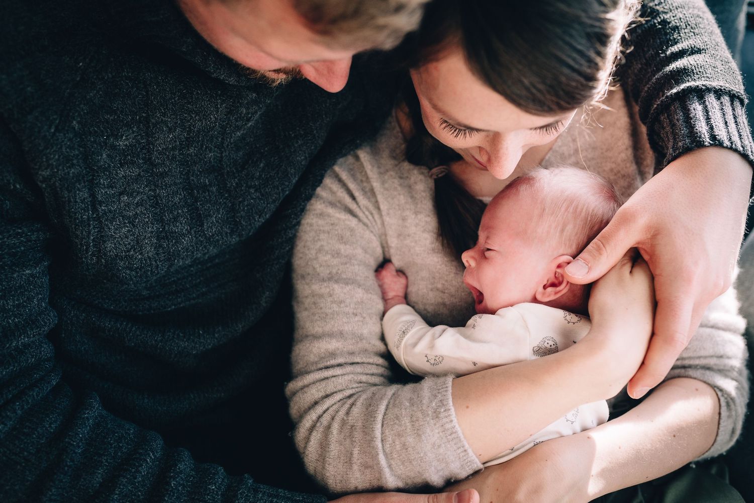 Neue Eltern bewundern ihr neugeborenes Baby.