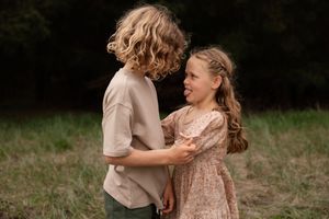 brother and sister looking at each other messing around during family session at Bottle lake forest