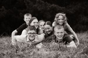 grandkids climbing on top of each other, having fun during family session at Bottle lake forest Christchurch