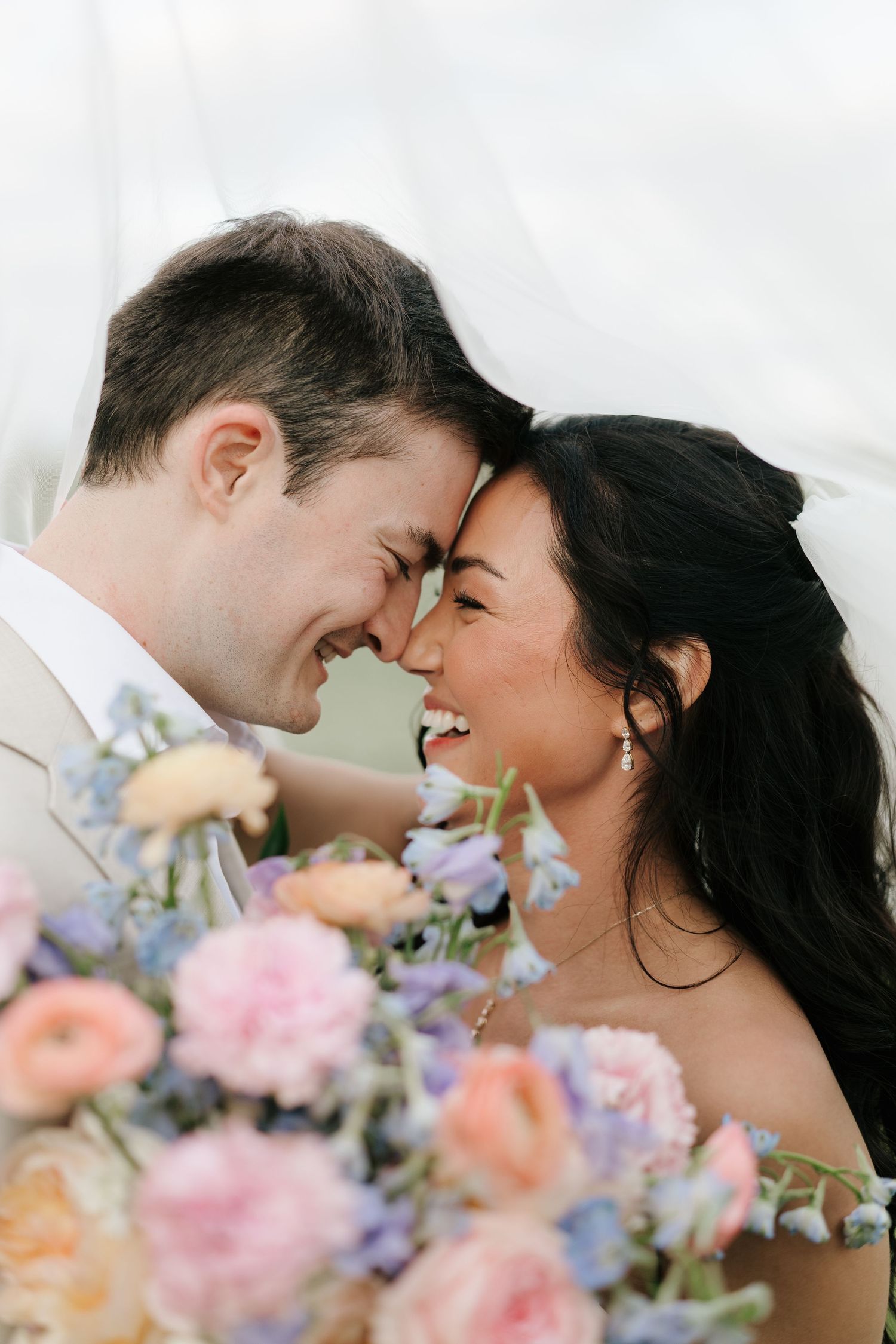 A romantic wedding moment with rings being exchanged outside in front of brick walls and greenery.