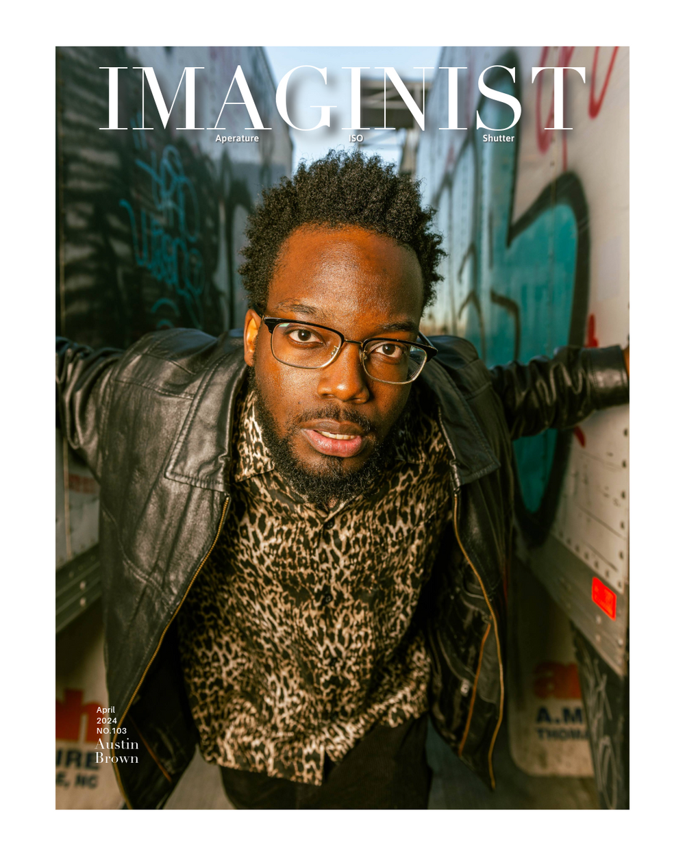 Magazine cover featuring someone wearing glasses, a black leather jacket and an animal print scarf against an urban backdrop.