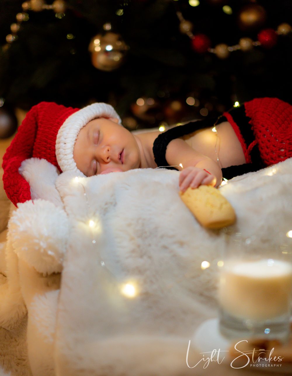 Children photographer captured a a baby posing with Santa hat and Christmas outfit during kids mini session in Charlotte.