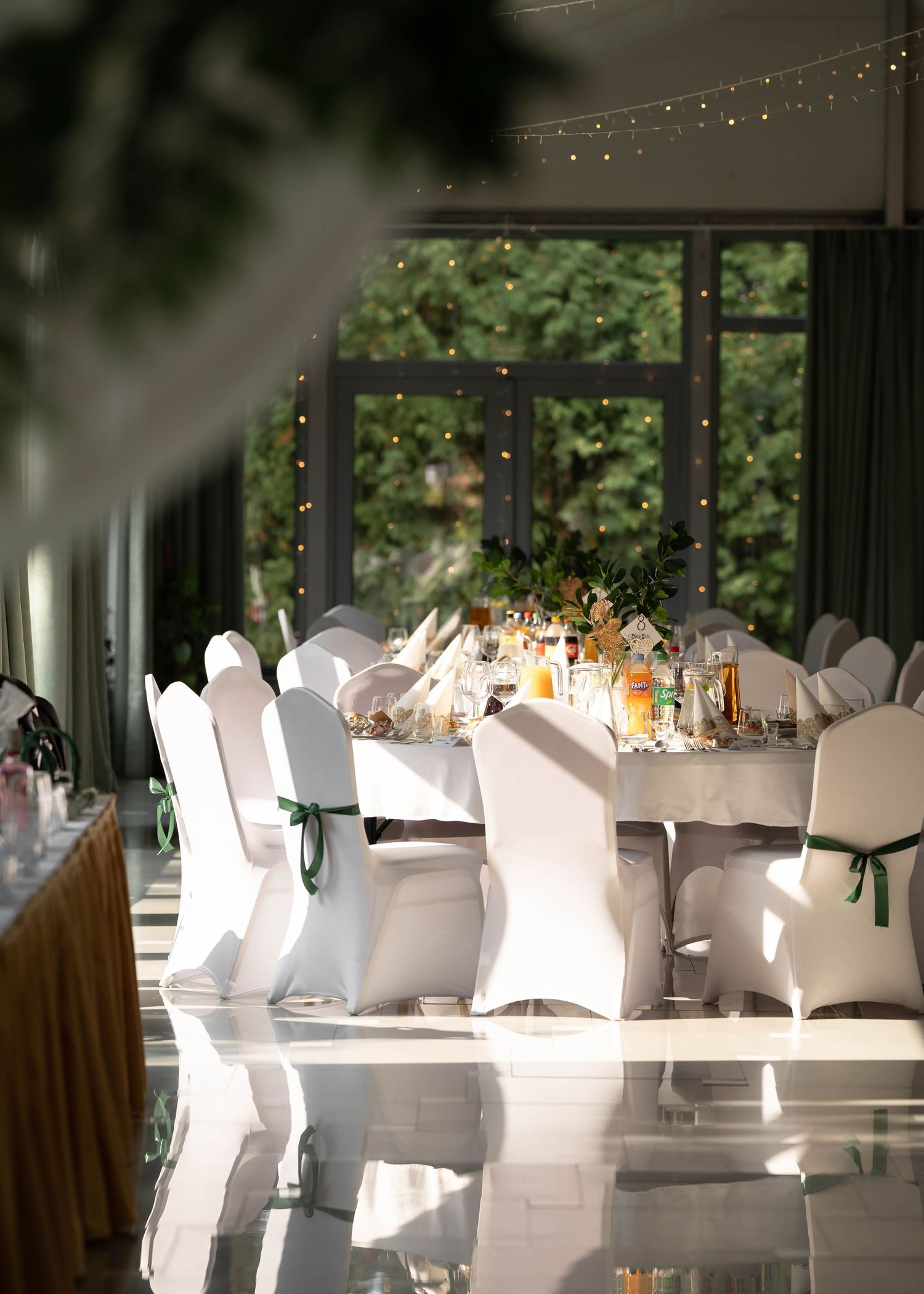 Elegant wedding reception setup with white chair covers and romantic candlelit table settings.