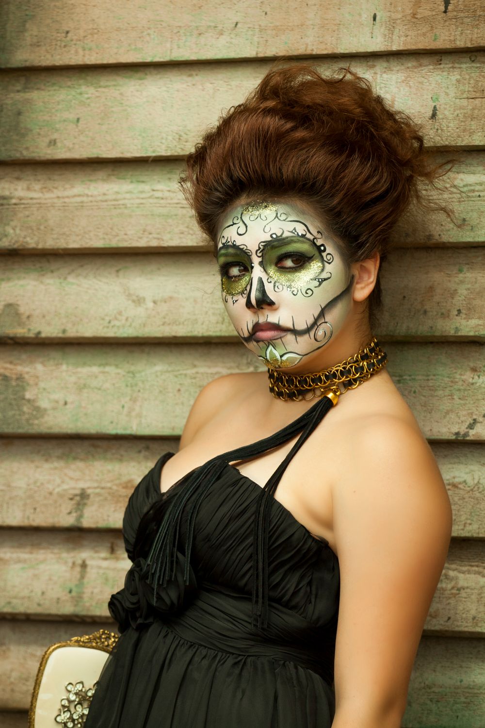 Day of the Dead inspired makeup with intricate face painting and black dress.