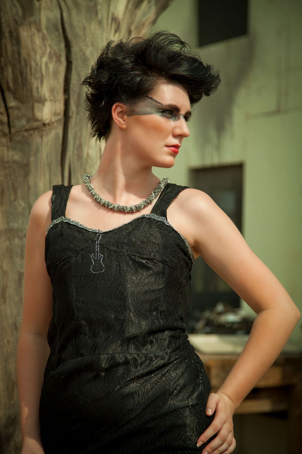 Retro-styled portrait in black dress with statement necklace and dramatic hairstyle.