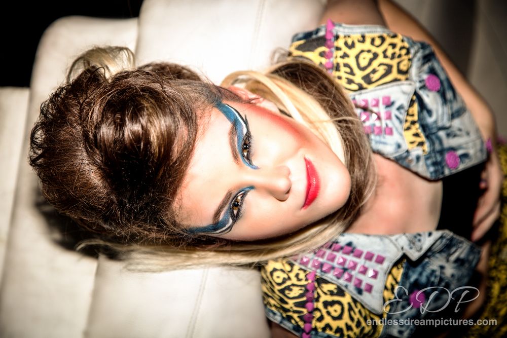 Fashion portrait with dramatic makeup and colorful patterned clothing.