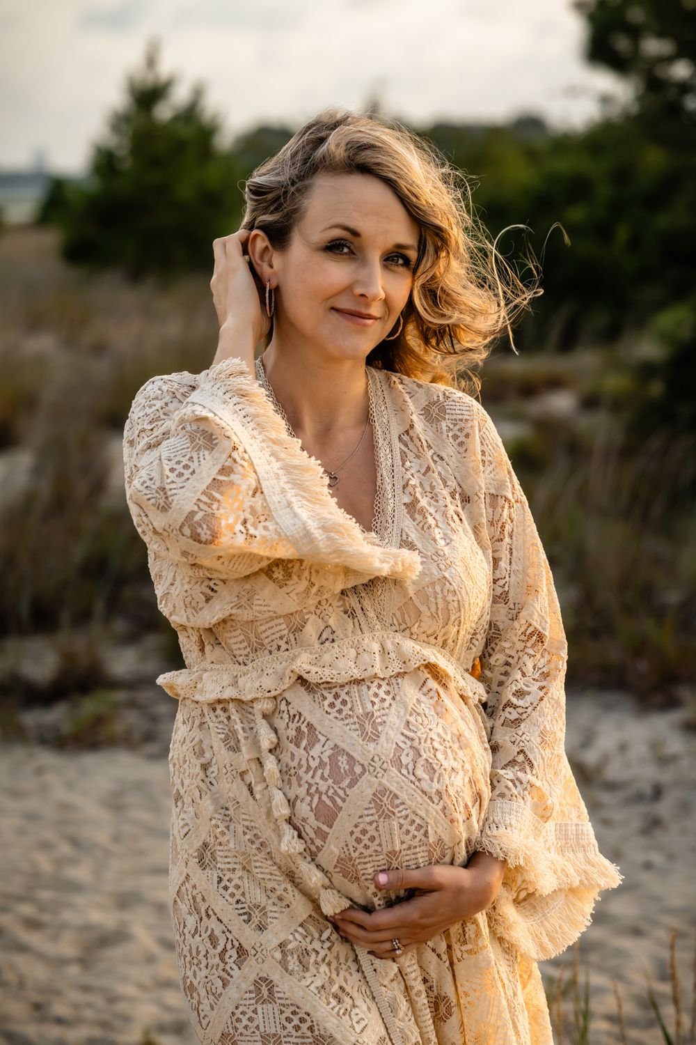 A radiant maternity portrait in soft natural light with coastal scenery.