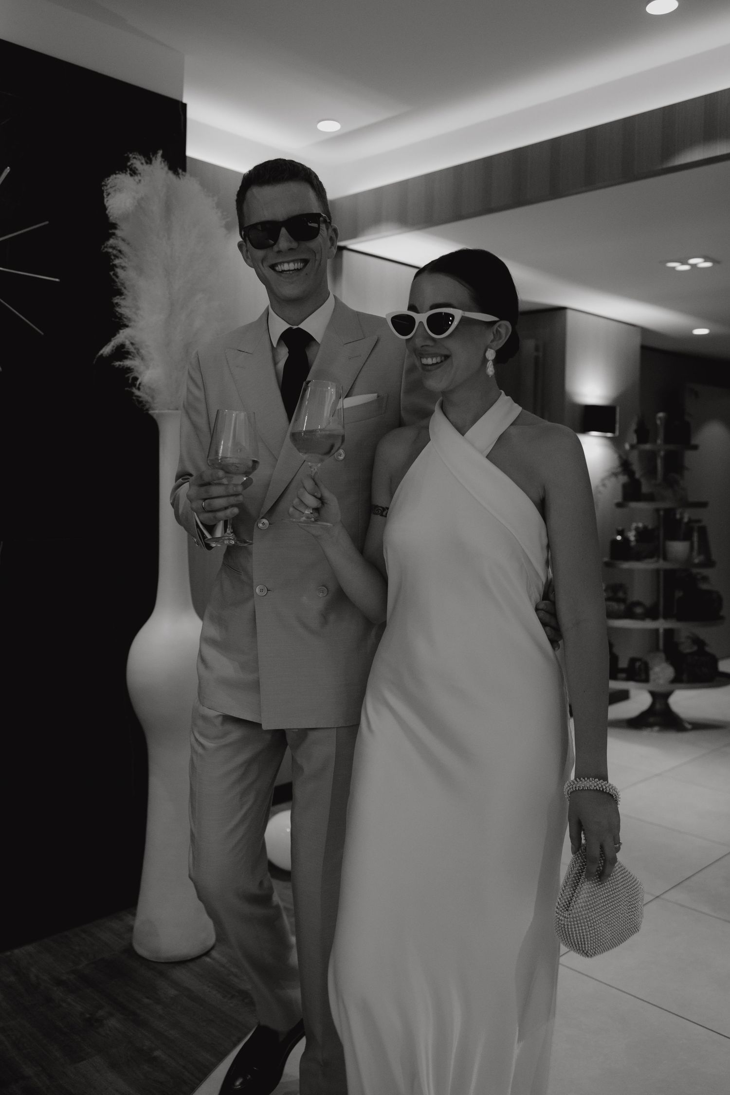 Elegant couple in coordinating formal attire pose at a stylish indoor event.