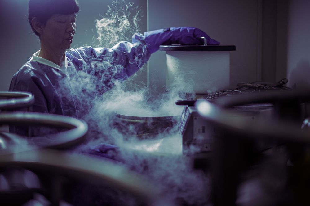 Smoke billows around chef preparing food in dimly lit kitchen.