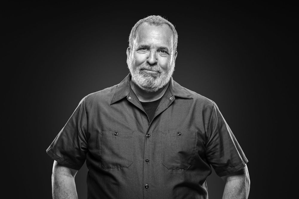 Professional black and white headshot of a person in casual attire.