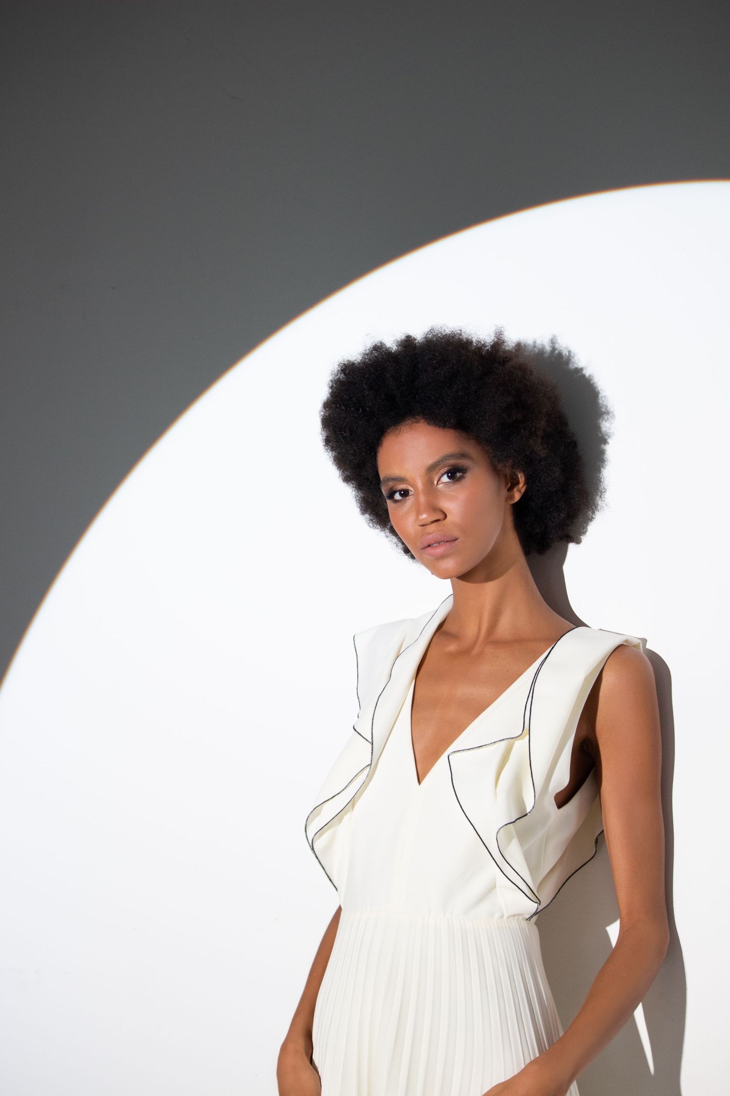 High quality studio photo of a female model with flawless skin and minimal makeup. Clean lighting and modern fashion styling. Editorial