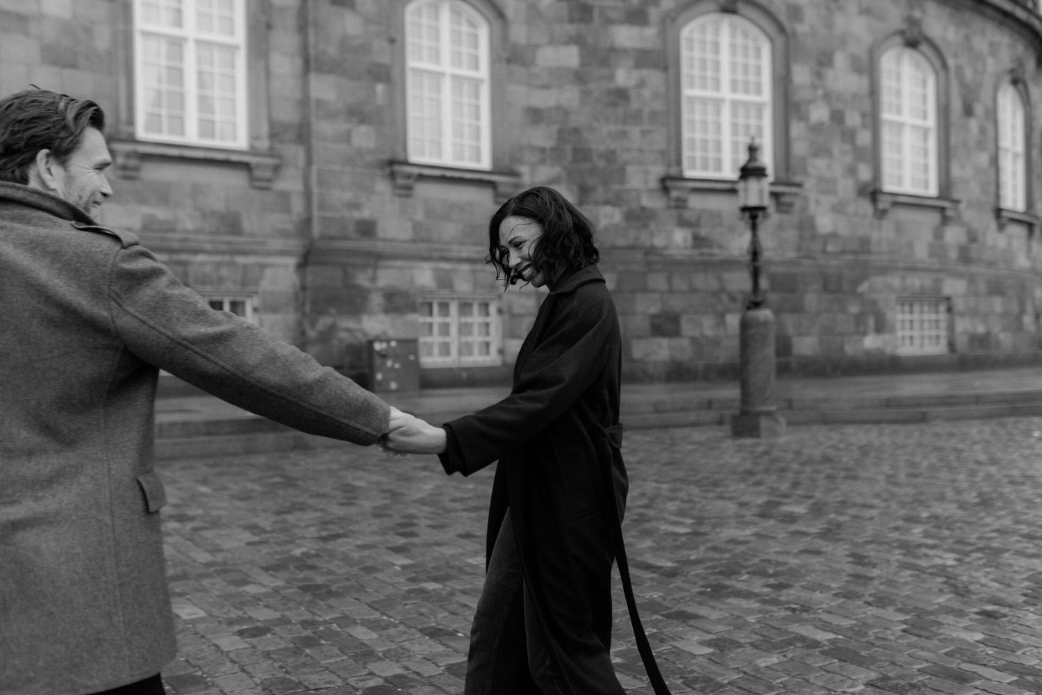 Black and white photo series showing movement sequence of someone falling backwards on a stone courtyard.