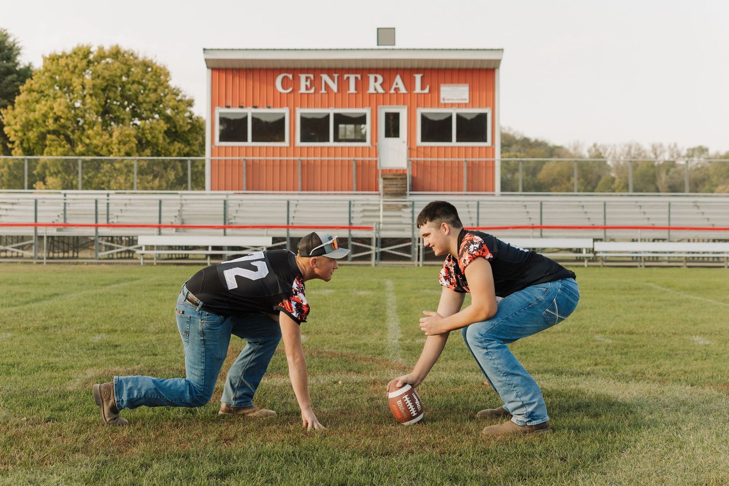 Football player performs action sequence poses on field in front of Central High School building.