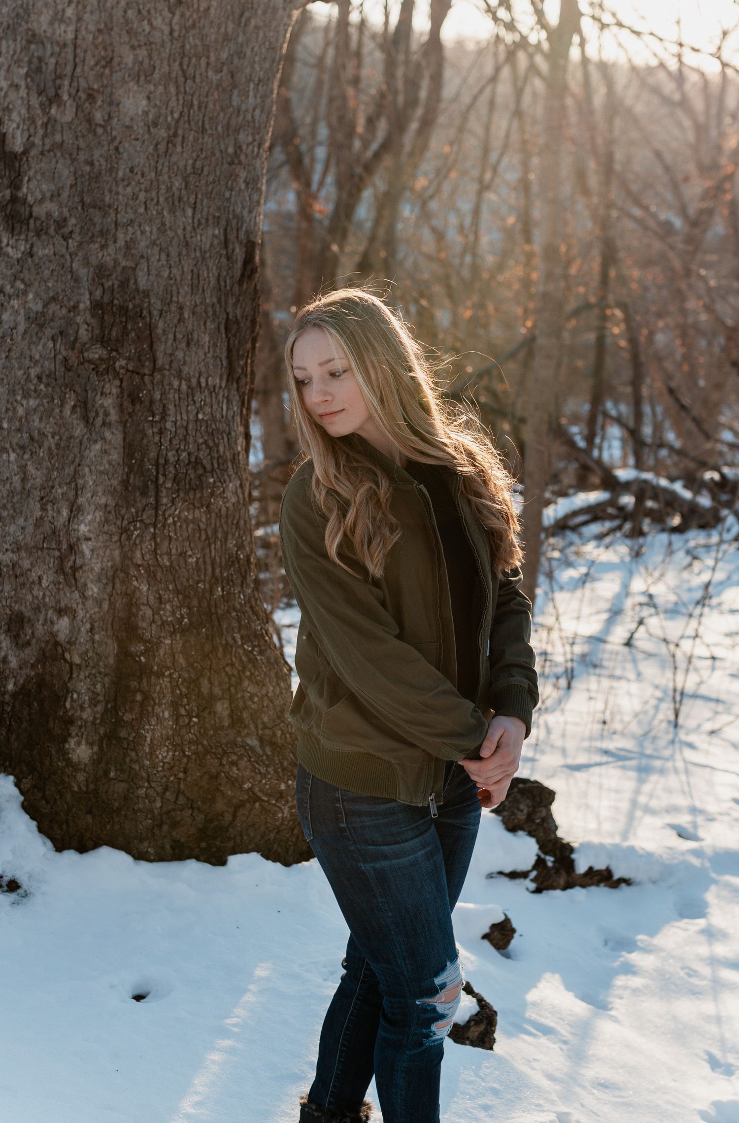 A sequence of photos shows someone walking through a snowy forest landscape wearing a dark coat and jeans.