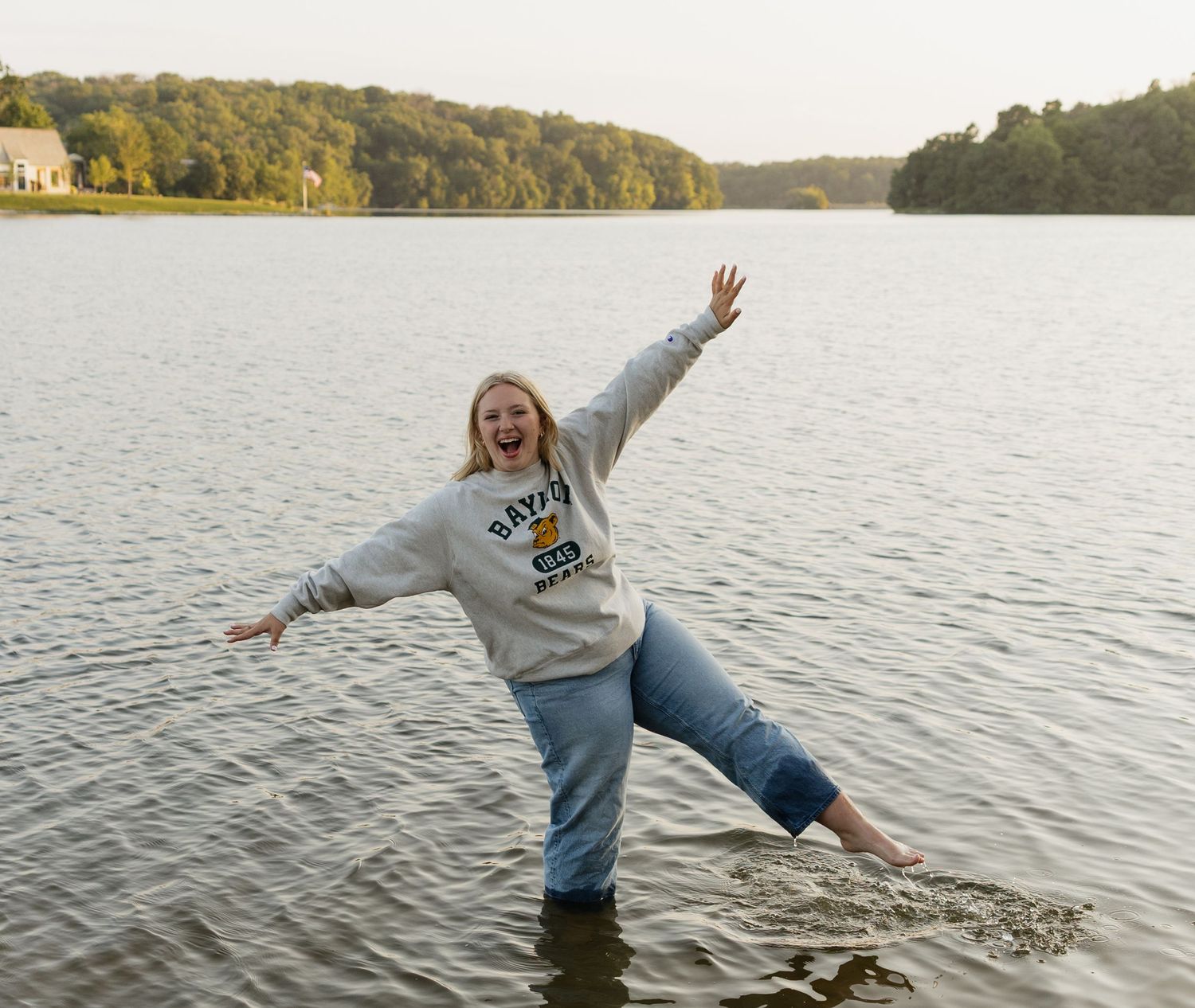 A series of playful moments captured by a lake at sunset showing someone jumping and splashing in the calm waters.