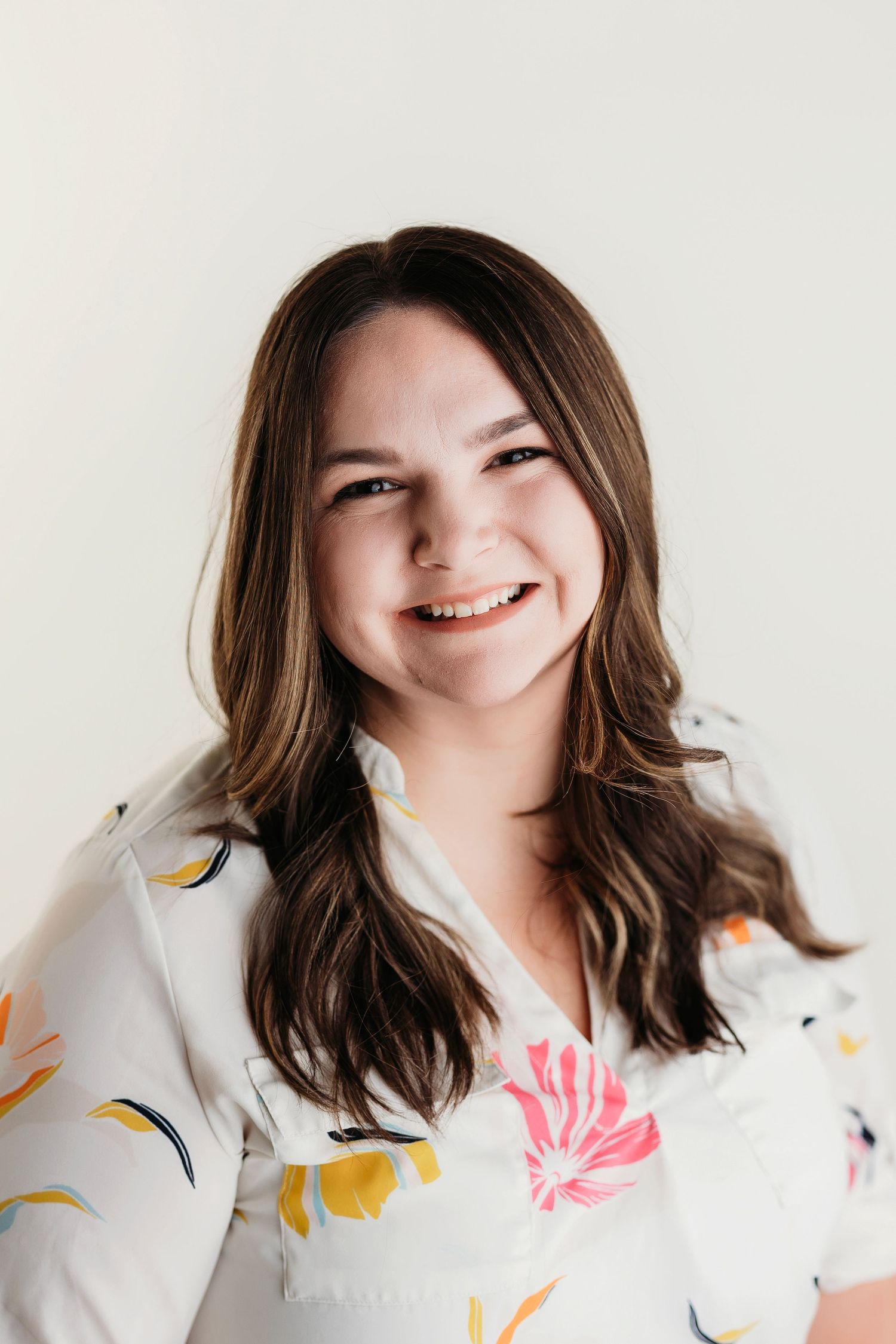 A series of four photos showing someone in a white floral dress smiling and posing against a light background.