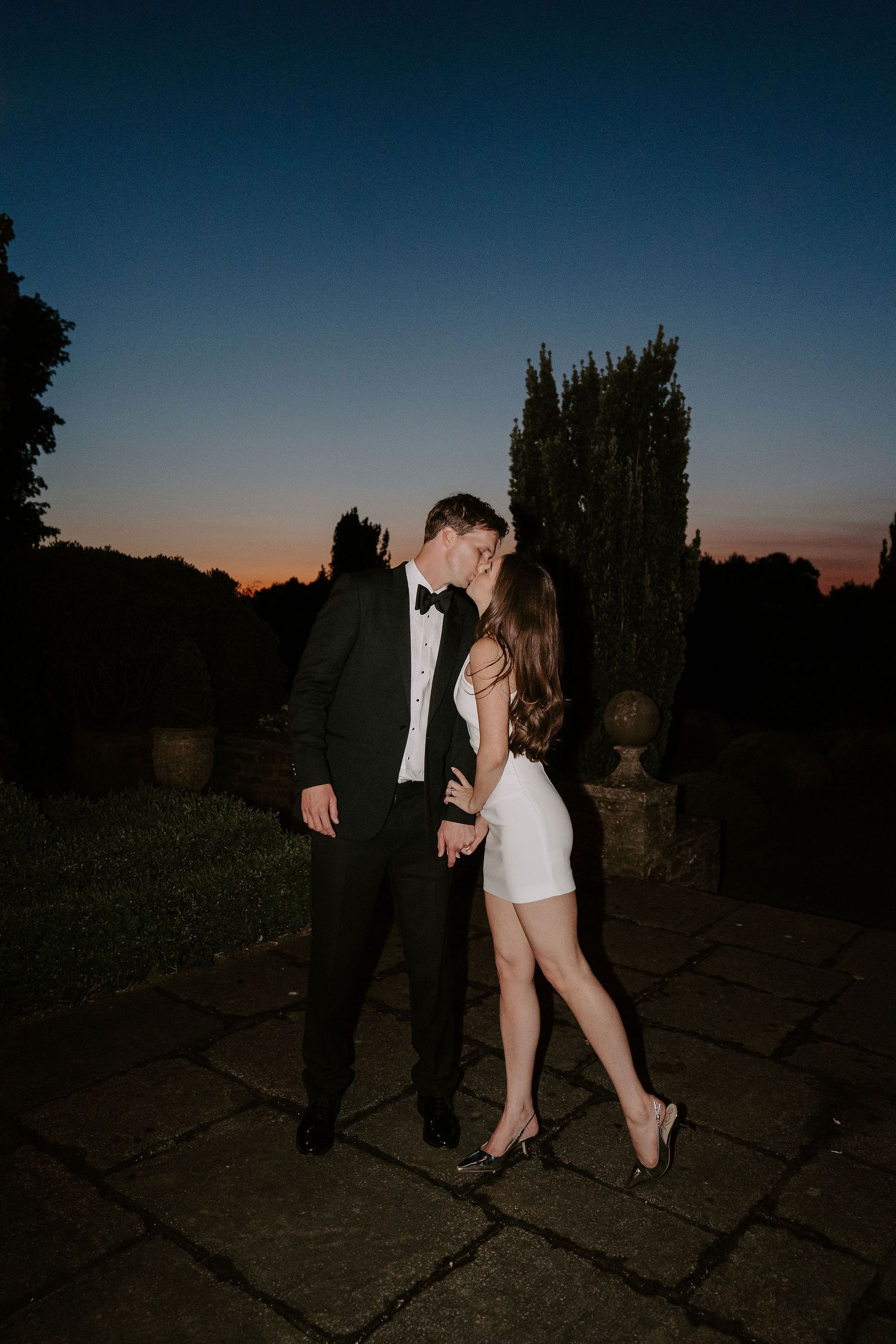 bride and groom kissing in the last of the sunlight setting on the horizon at dewsall court in herefordshire